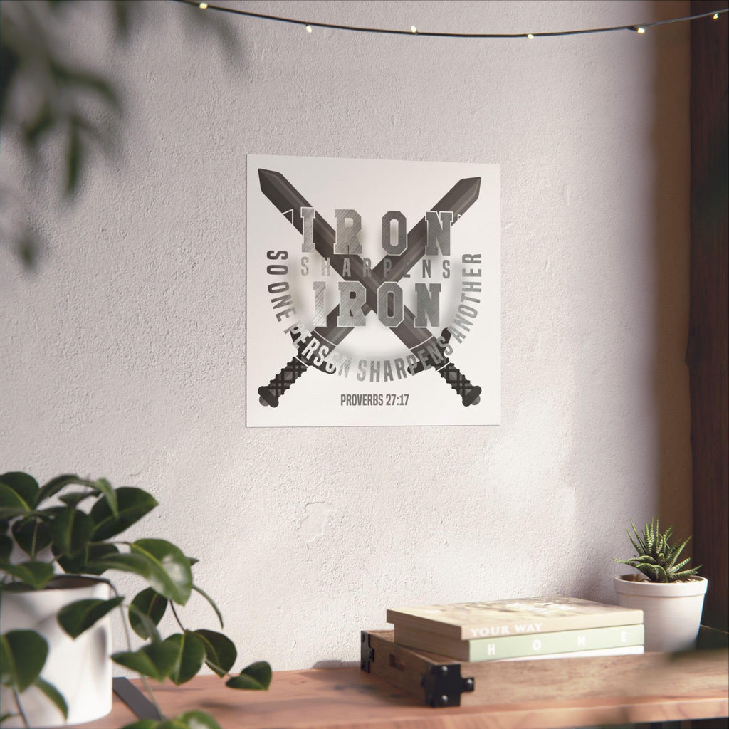 Square Iron Sharpens Iron poster with crossed swords and Proverbs 27:17 displayed above a desk