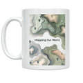 White Mapping Our World mug with green and tan topographic contours and map pins
