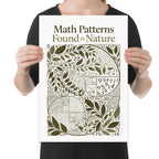 Person holding the math patterns in nature poster to show its layout